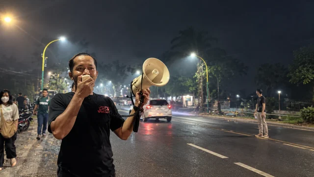 Ketua GAPURA Aris berorasi menggunakan pengeras suara di tengah kabut asap saat mendesak evaluasi penanganan karhutla di Palangka Raya, Kalteng.